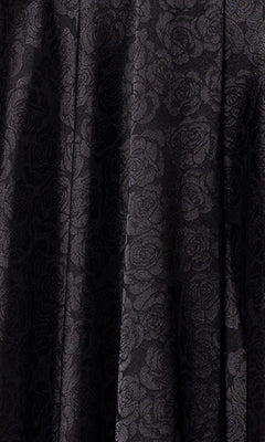 Close-up of black fabric with a subtle rose floral pattern and slight folds, ideal for the Strapless Black Prom Gown: Blondie Nites 5301BN—perfect for an elegant junior-sized evening or prom look.