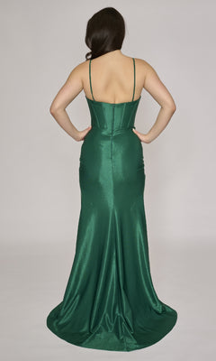A woman is shown from the back in the Long Prom Dress: Nina Canacci 5303—a long emerald green satin gown with thin straps and a corset bodice—standing against a plain light background.