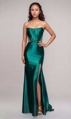 A woman wears the Nina Canacci 5307 long formal dress in emerald green satin, featuring a strapless fitted bodice and a thigh-high slit, standing against a plain light background.