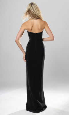 A woman with long blonde hair is wearing the Jovani 53108 Long Formal Dress, a strapless, floor-length black gown, standing with her back to the camera against a plain light gray background.