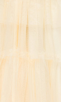 Close-up of soft, layered, cream-colored tulle with a semi-transparent look, similar to the delicate texture featured on the Long Yellow Halter Prom Gown: Blondie Nites 5349BN.