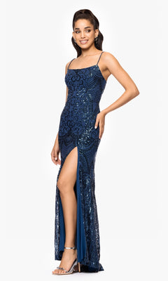 A woman in the Blondie Nites 5377BN long sequin-print prom dress, featuring thin straps and a high thigh slit, stands against a white background styled with silver heels and earrings.
