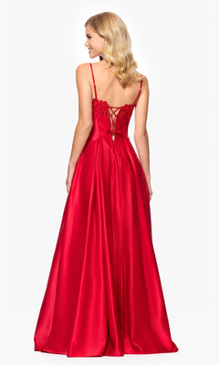 A woman stands facing away, wearing the Classic Long Prom Dress: Blondie Nites 5387BN in bold red satin, featuring a stunning lace-up back and reminiscent of a sweetheart prom style.
