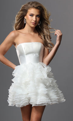 A woman is wearing the Short Homecoming Dress: Jovani 53955 in white, which features a strapless fitted satin bodice and a layered ruffle tulle skirt, as she stands against a plain gray background.