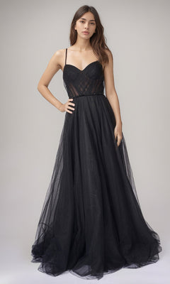 A woman poses in a studio wearing the black Nina Canacci 5401, a long formal dress with a fitted bodice and full glitter tulle skirt for an elegant sleeveless A-line look.