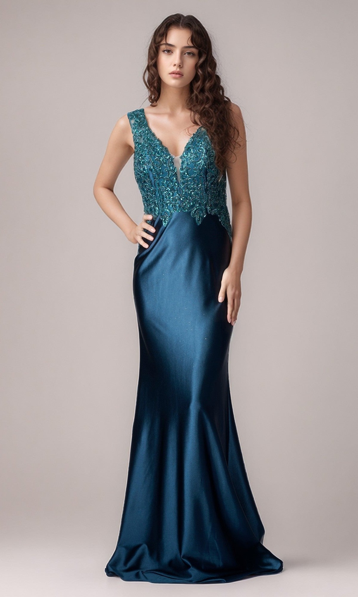 A woman stands against a plain background wearing the Nina Canacci 5411—a sleeveless, dark teal floor-length formal dress with a fitted bodice and deep V-neckline.