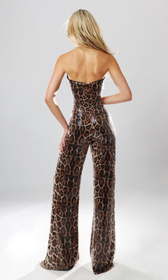 A person with long blonde hair models the Jovani 54171 Long Formal Jumpsuit, a strapless piece showcasing a fitted silhouette and striking brown and black leopard print, viewed from the back against a plain light background.