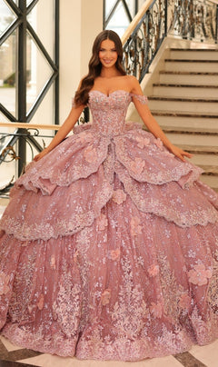 A woman stands on an ornate staircase wearing the Quinceanera Dress 54202 By Amarra, a voluminous off-the-shoulder ball gown adorned with lace-embroidered flowers and delicate floral details.