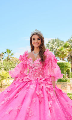 A young woman smiles outdoors among trees and hedges, wearing the Quinceanera Dress 54218 By Amarra—a bright pink ball gown with puff sleeves and a tiara.