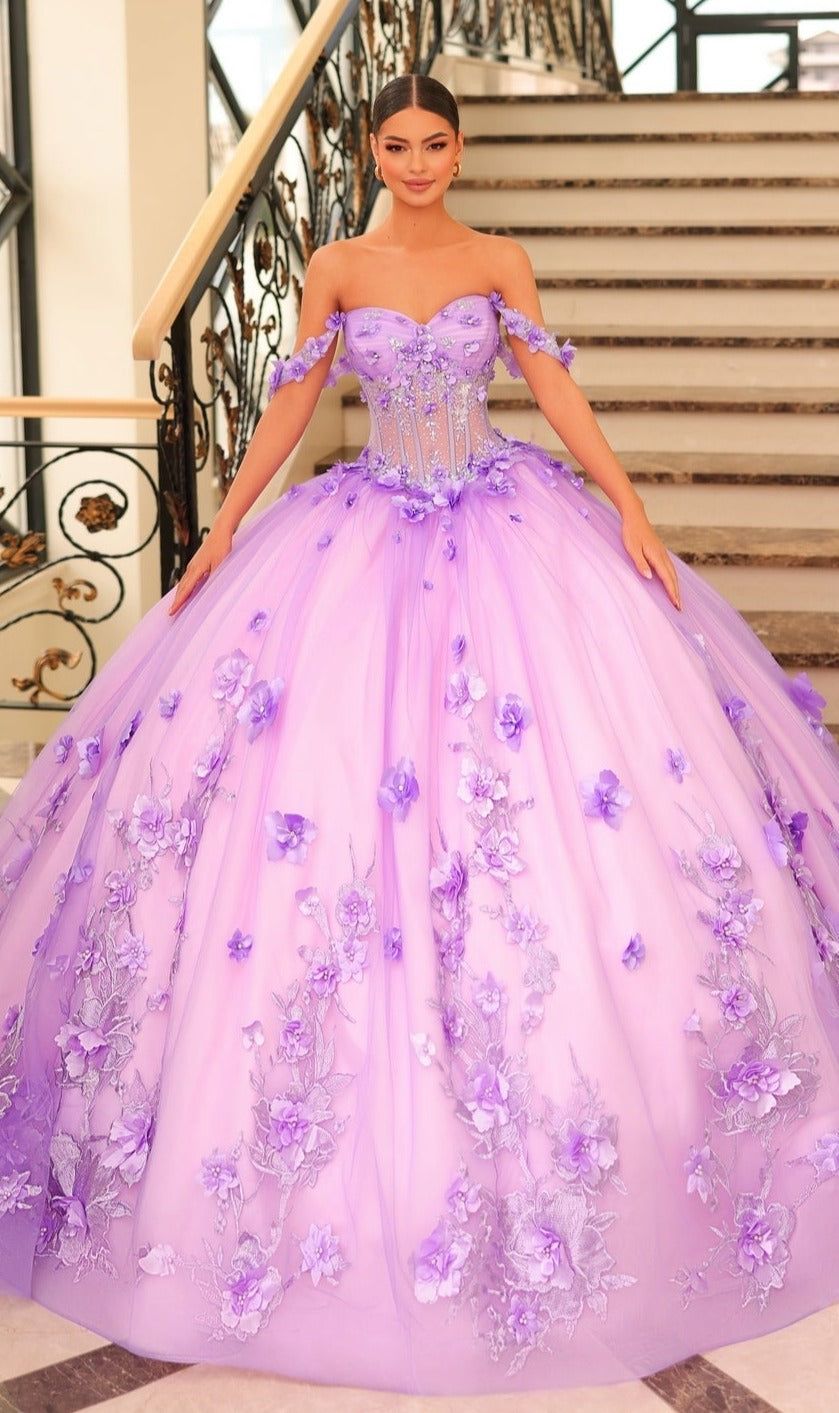 A woman stands on a staircase wearing the Quinceanera Dress 54224 by Amarra, a lavender tulle ball gown with floral appliqués and elegant off-the-shoulder sleeves.