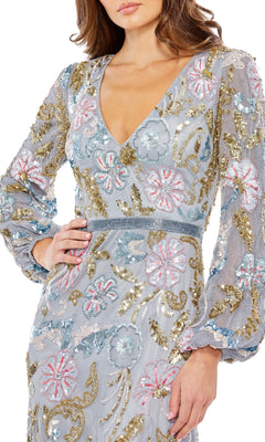 A woman in the Mac Duggal 5423 Midi Wedding Guest Dress, featuring long sleeves, a V-neck, and blue, gold, and pink floral embroidery with sequins and beaded accents—an elegant choice for wedding guests.