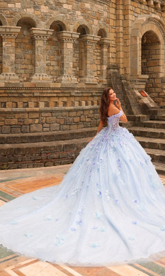 Wearing the Amarra 54231 3D Floral Quinceañera Dress, a woman stands outdoors before a stone building, glancing over her shoulder.