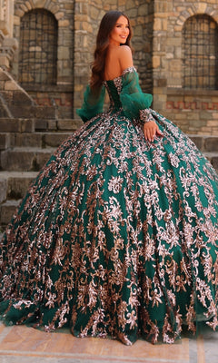 A woman stands on stone steps wearing the Amarra 54238 Sequin Quinceanera Dress, featuring a corset bodice, silver embroidery, and a voluminous green skirt.