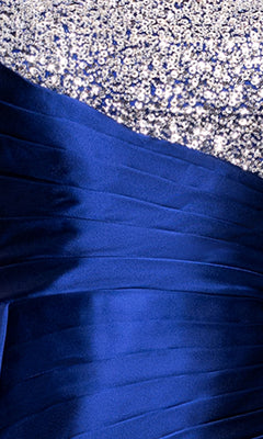 Close-up of the Blondie Nites 5423BN dress, a long blue formal gown with sequin embellishments, featuring a silver upper section and a shiny pleated blue lower half—ideal for any formal occasion.