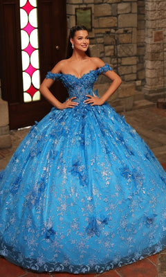 A woman poses indoors, smiling with her hands on her hips in the Amarra 54243 Off-Shoulder Quinceanera Dress, featuring lace details and a full skirt.