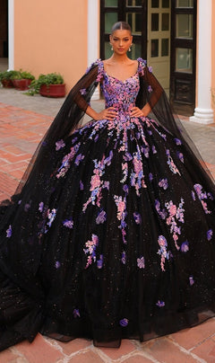 A woman stands outdoors in the Quinceanera Dress 54318 By Amarra, a stunning ball gown adorned with purple and lavender floral appliqu‚s, sheer cape sleeves, and elegant embroidery.
