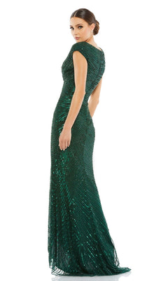 Woman wearing the Mac Duggal 5441 Cap-Sleeve Sequin Formal Dress, a floor-length, fitted dark green gown with cap sleeves, stands and looks over her shoulder against a white background.