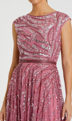 A woman wearing the Mac Duggal 5445 high-neck beaded formal gown, a sleeveless pink dress featuring silver sequin embellishments in a wavy pattern.