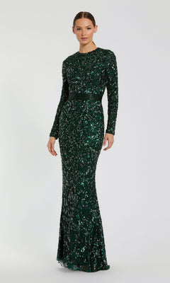 A woman wears the Mac Duggal 5453 long sleeve sequin formal dress, featuring a fitted silhouette in green, styled as an elegant evening gown against a simple light background.
