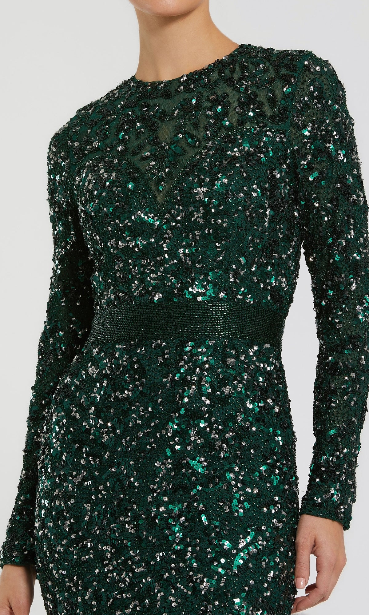 Wearing the Mac Duggal 5453 Long Sleeve Sequin Formal Dress in green, this person stuns in a fitted evening gown featuring shimmering sequins and a sheer neckline panel.