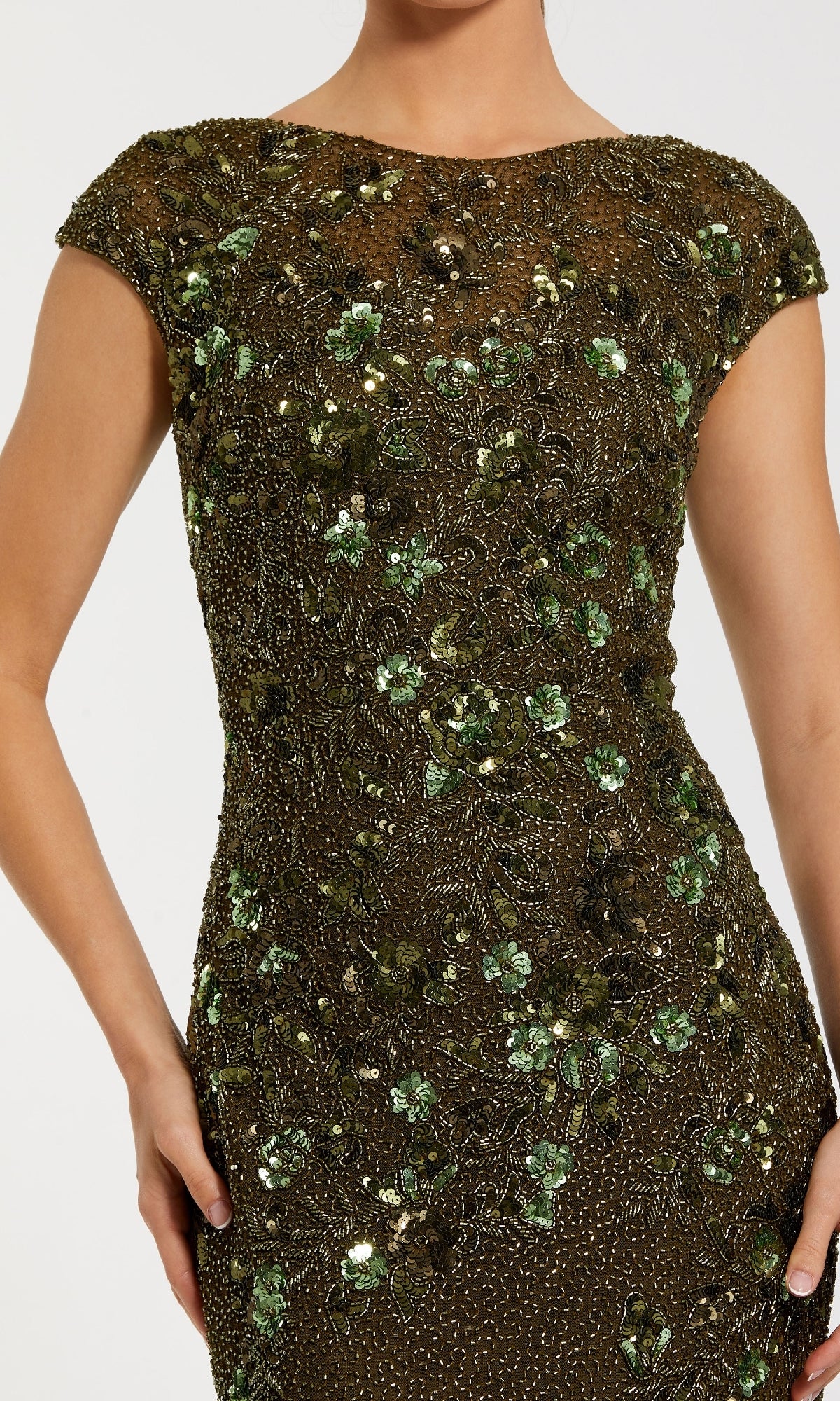 Someone wearing the Mac Duggal 5500 Beaded Long Formal Dress, featuring fitted short sleeves and adorned with green and gold floral sequin and bead embellishments.