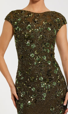 Someone wearing the Mac Duggal 5500 Beaded Long Formal Dress, featuring fitted short sleeves and adorned with green and gold floral sequin and bead embellishments.