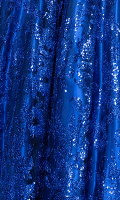 Close-up of the blue fabric on the Long Glitter Prom Dress: Blondie Nites 5501BN, featuring intricate sequin and embroidered patterns for a shiny, textured surface reminiscent of an elegant evening gown.
