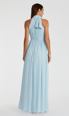 A woman faces away, wearing the Mac Duggal 55035 High-Neck Long Formal Dress in light blue, featuring pleated detailing and a draped back bow.