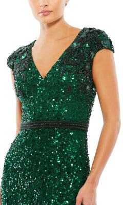Someone wearing the Long Formal Dress 5505 by Mac Duggal, featuring deep green color, short sleeves, V-neckline, black beaded embellishments, a beaded waistband, and a bra-friendly design.