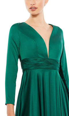 Woman in a deep green satin Mac Duggal 55245 long sleeve formal dress, featuring a deep V-neckline, ruched waistband, and elegant A-line silhouette—perfect for evening events.