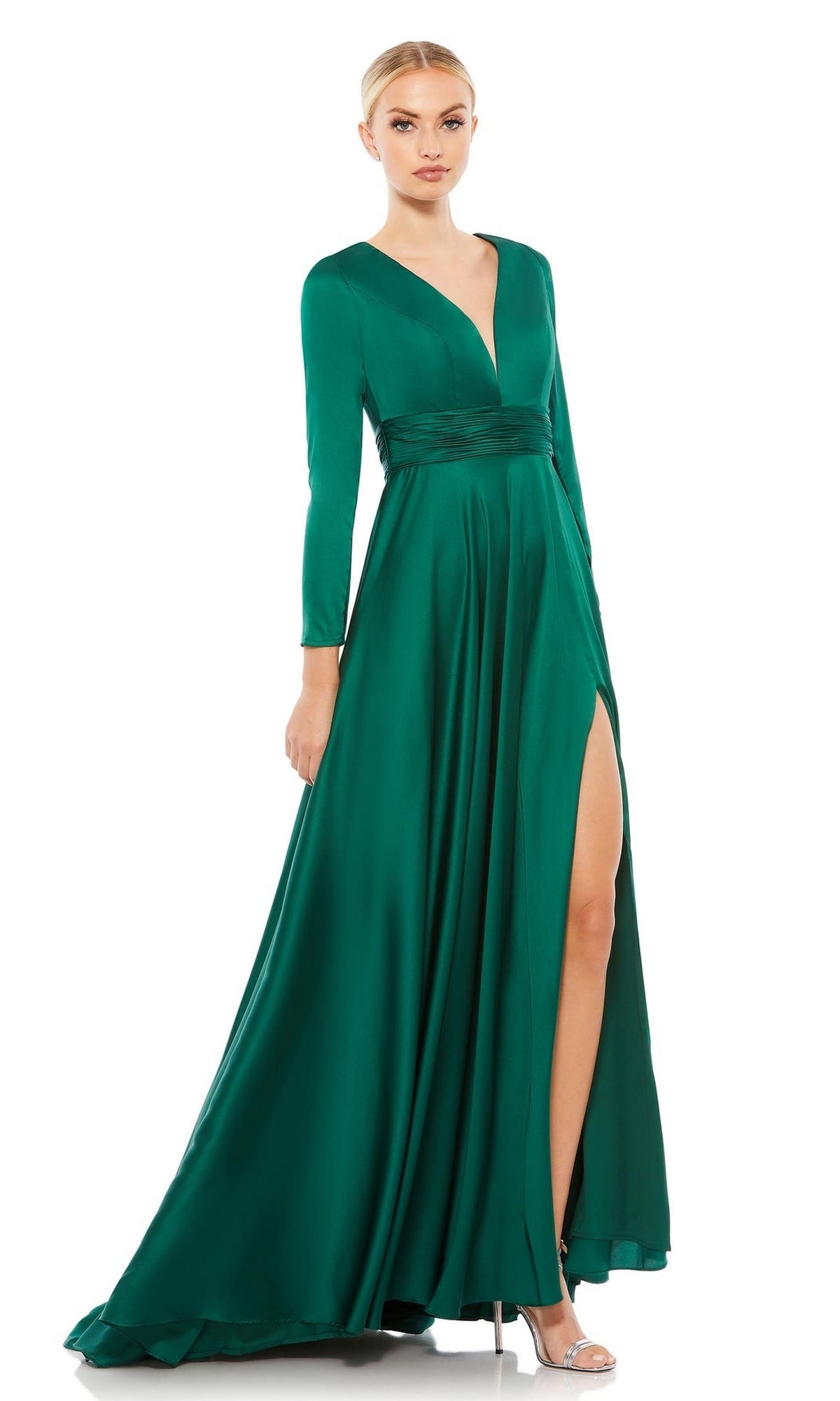 Woman in the Mac Duggal 55245: a green satin long sleeve A-line formal dress with deep V-neck, high waist, and thigh-high slit, styled with silver heels.