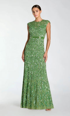 A woman wears the Mac Duggal 5532, a silver long sequin formal dress, featuring dazzling embellishments, standing against a plain light background.