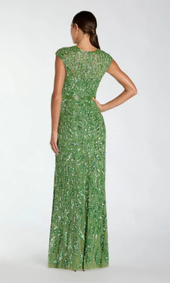 A woman faces away, wearing the Mac Duggal 5532 Silver Long Sequin Formal Dress with cap sleeves, a fitted waist, and sparkling sequin embellishments.