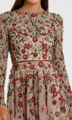 A close-up of the Beaded Long Sleeve Formal Dress: Mac Duggal 5533, showcasing sheer fabric with detailed red, green, and silver floral embroidery and beadwork.