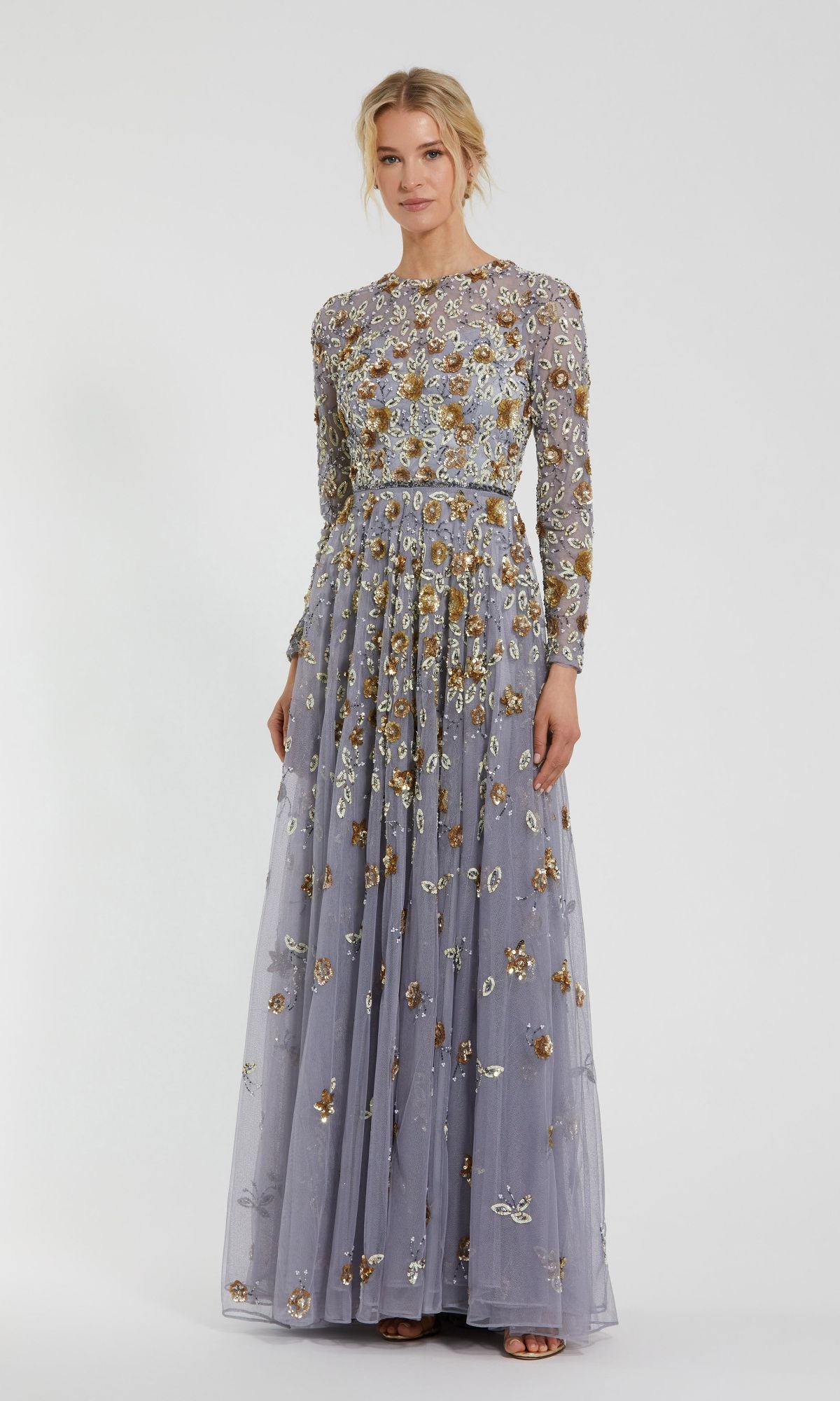 A woman wears the Beaded Long Sleeve Formal Dress: Mac Duggal 5533, a floor-length lavender gown with long sleeves and floral embroidery, standing against a plain white background.