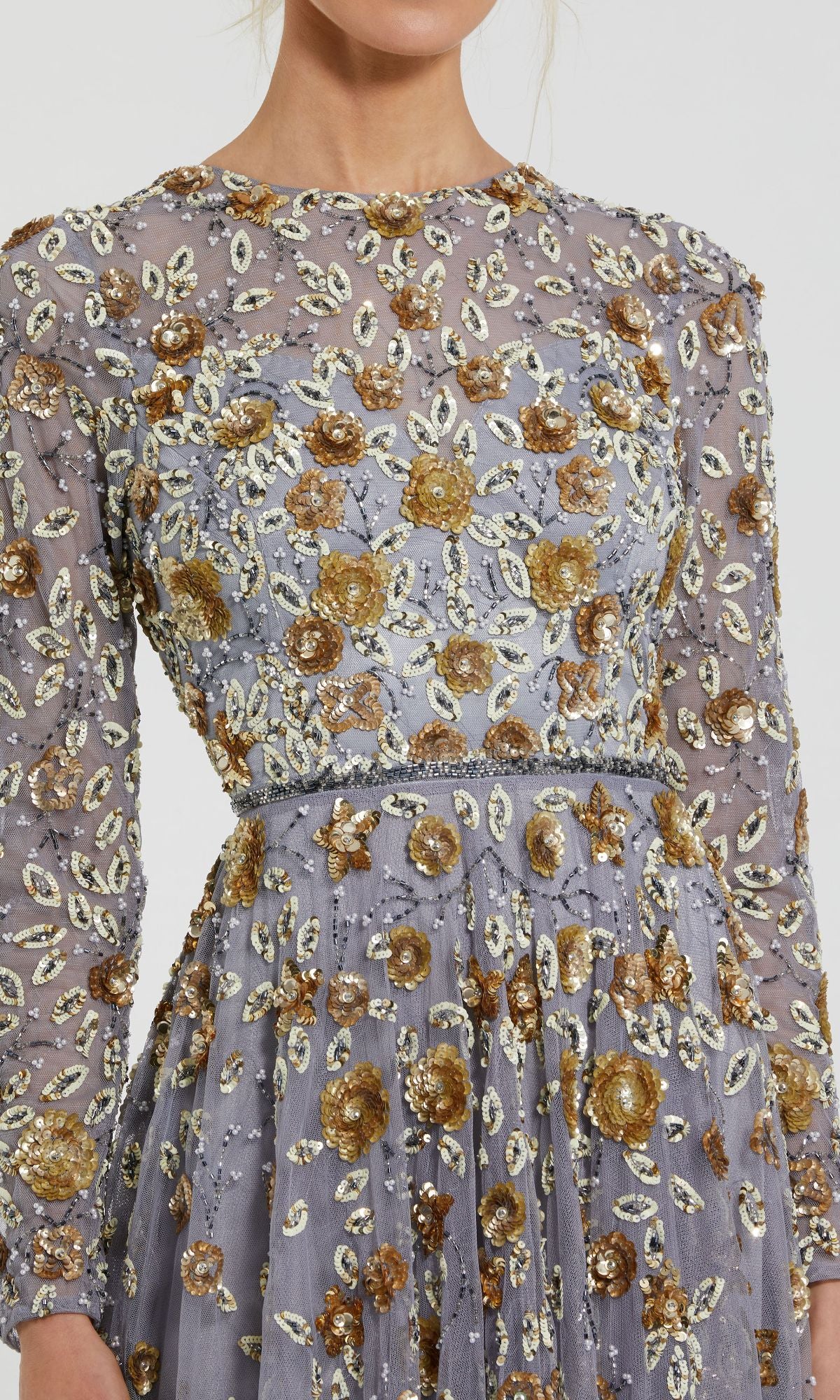 A close-up of a person wearing the Mac Duggal 5533 Beaded Long Sleeve Formal Dress, featuring sheer lavender fabric and gold and silver floral embellishments for an elegant, formal look.