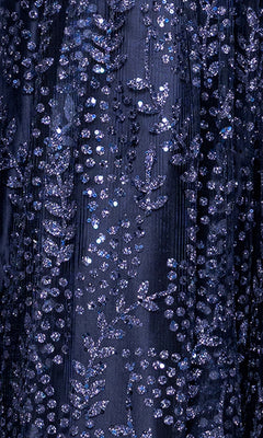Close-up of the Glitter-Print Prom Ball Gown: Blondie Nites 5539BN, featuring dark blue fabric embellished with shimmering sequins and intricate leaf and dotted patterns.