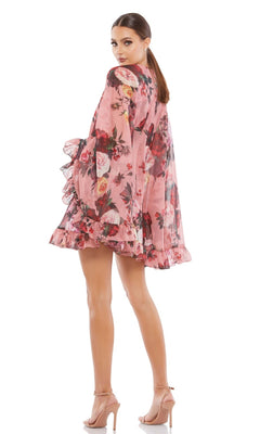 A woman wearing the Mac Duggal 55404 Short Print Cape Hoco Dress stands in nude heels, looking over her shoulder.