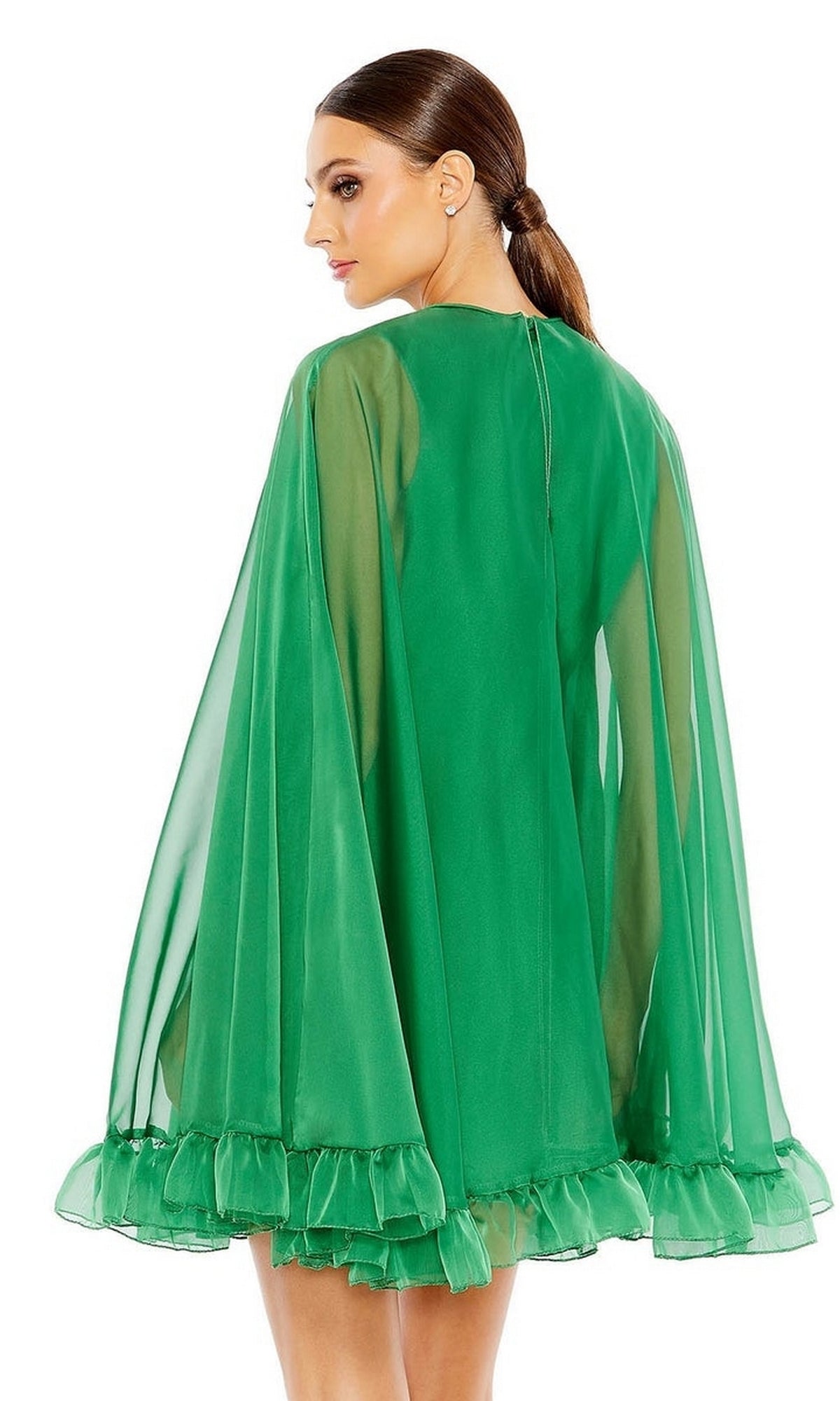 A woman is seen from the back wearing a bright green Mac Duggal 55407 Cape-Sleeve Short Ruffled Party Dress, with sheer long sleeves, ruffled cuffs and hem. Her hair is in a low ponytail, creating an elegant semi-formal cocktail look.