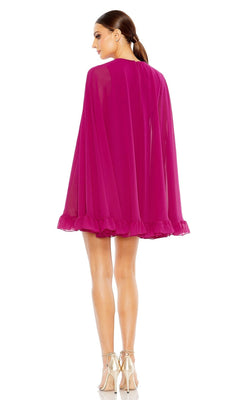 A woman in a Mac Duggal 55407 Cape-Sleeve Short Ruffled Party Dress with a sheer knee-length hem stands facing away, her hair in a ponytail and wearing strappy heels.
