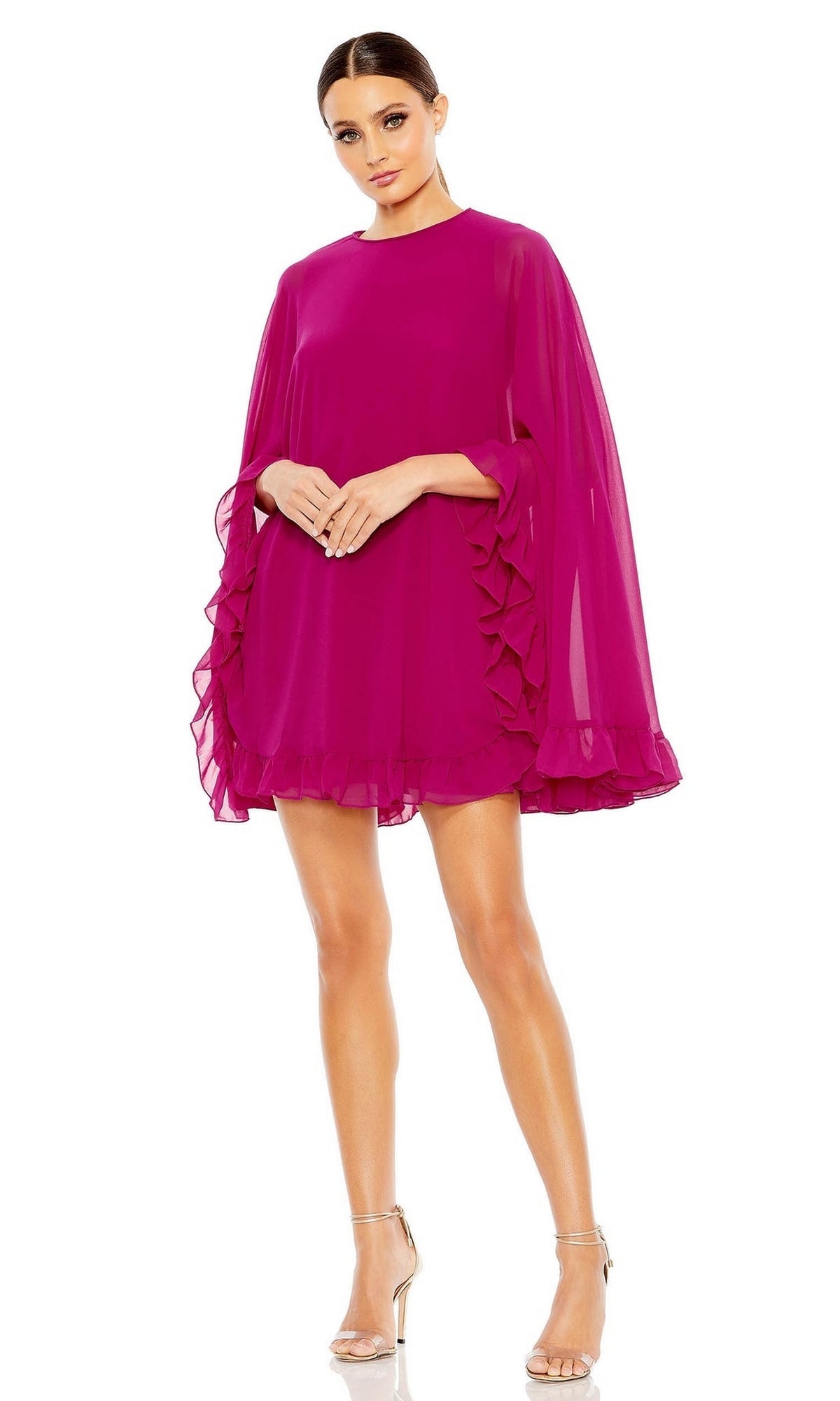 A woman stands against a white background wearing the Mac Duggal 55407 Cape-Sleeve Short Ruffled Party Dress in bright magenta with sheer sleeves and clear-strap heels.