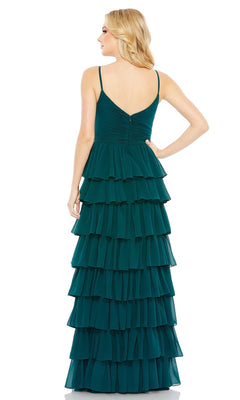 A woman faces away, wearing the Mac Duggal 55416 Ruffled Long A-Line Prom Dress—a sleeveless dark teal gown with thin straps and layered ruffles cascading down the skirt.