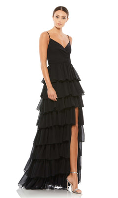 A woman models the Mac Duggal 55416 Ruffled Long A-Line Prom Dress, a sleeveless black evening gown with a high slit, paired with silver heels against a white background.