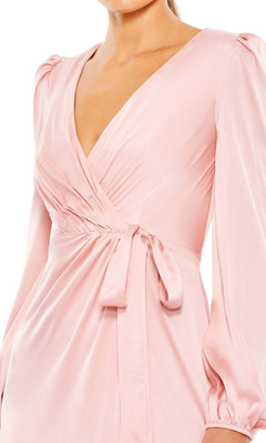 Someone wearing the Long Formal Dress 55624 by Mac Duggal—a rose pink, faux wrap style formal dress with a V-neckline, side tie detail, and long puff sleeves.