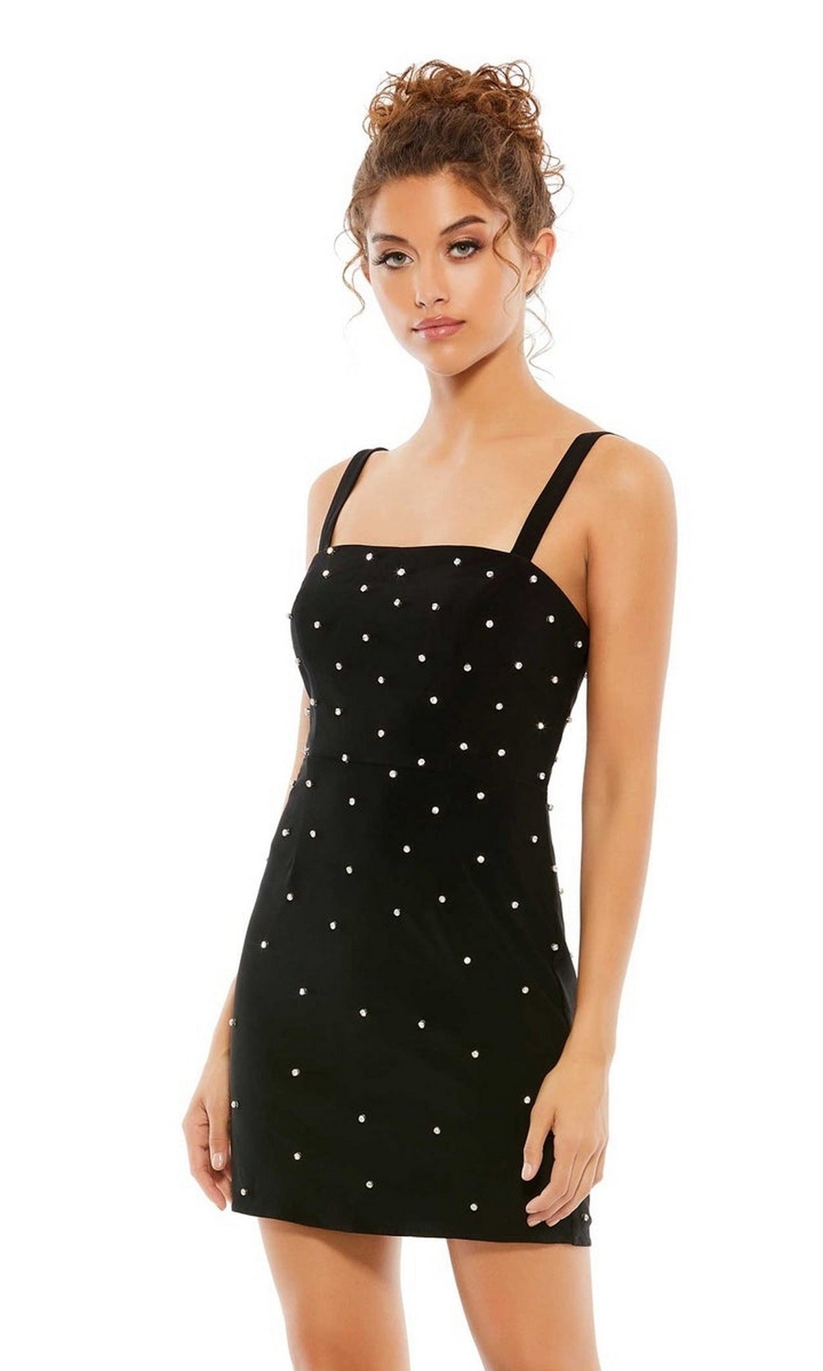 A woman models the Mac Duggal Short Homecoming Dress 55644, a sleeveless black party dress with white polka dot embellishments, against a plain white background.