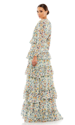 A woman faces away, wearing the Long Formal Dress 55664 by Mac Duggal—a floor-length gown with a light blue background, colorful floral print, and tiered ruffles.