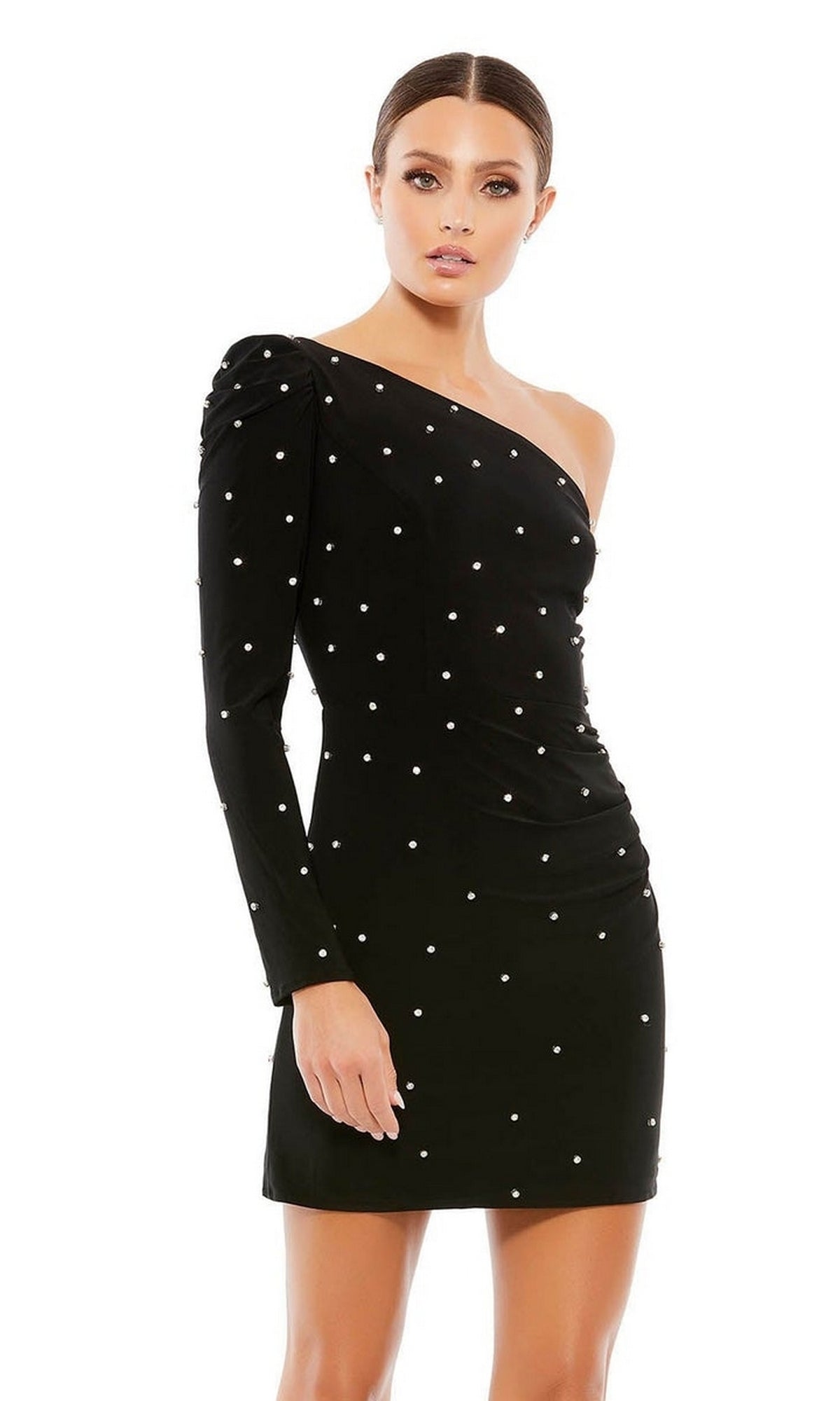 A woman stands against a white background wearing the Mac Duggal 55667 Short Black Pearl Hoco Dress, a fitted one-shoulder style with pearl-like embellishments.