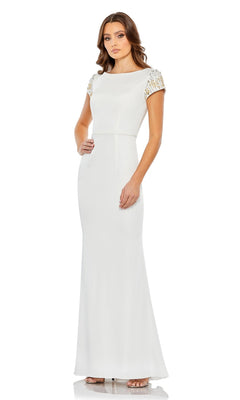 A woman stands against a plain white background wearing the Long Formal Dress 55718 by Mac Duggal, a floor-length column gown featuring a high neck and short, beaded sleeves.