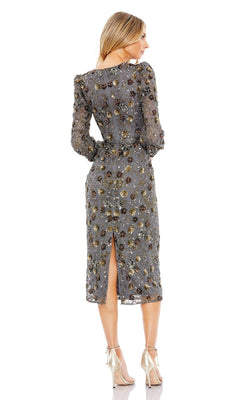 A woman faces away, highlighting the back slit and floral embroidery of the Mac Duggal Short Semi-Formal Dress 5571, a beaded charcoal long sleeve dress with a sheer knee-length design.