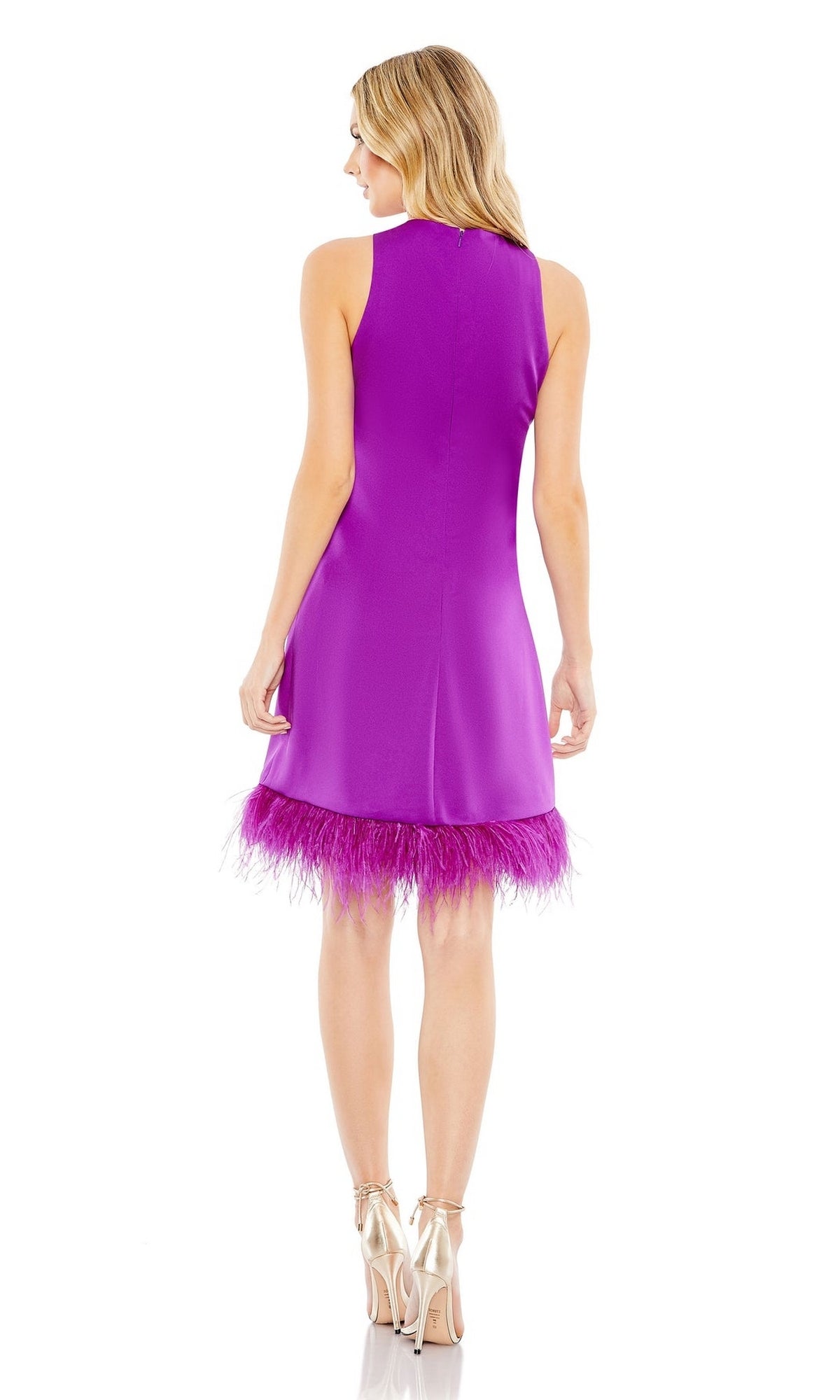 A woman with blonde hair faces away, wearing the Mac Duggal 55805 Short Sheath Wedding Guest Dress—sleeveless, knee-length, with feathered trim at the hem—and metallic high-heeled sandals.